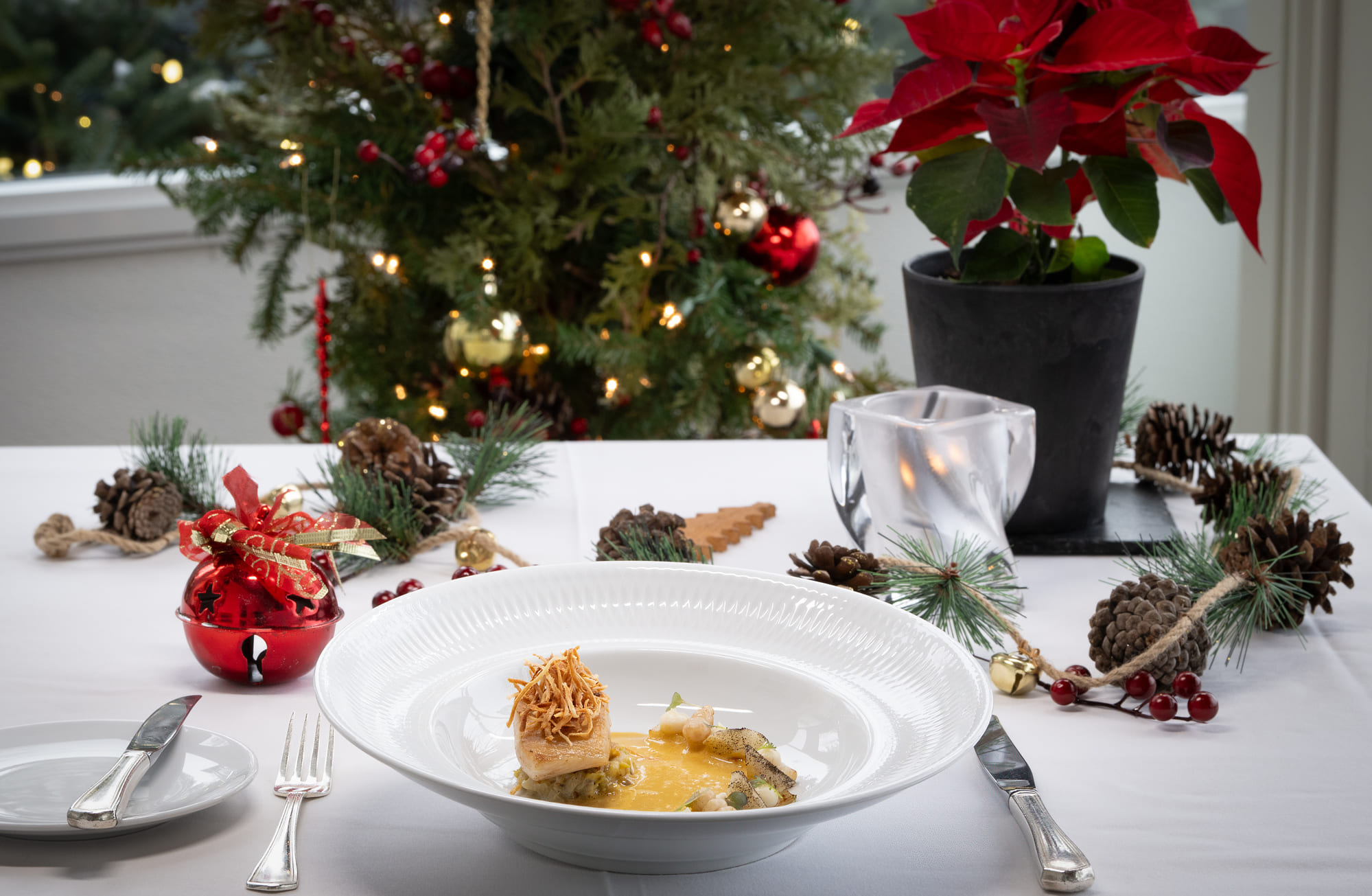 Table décorée pour le temps des fêtes au Ripplecove hôtel et spa, avec plat gastronomique et ambiance chaleureuse de Noël.