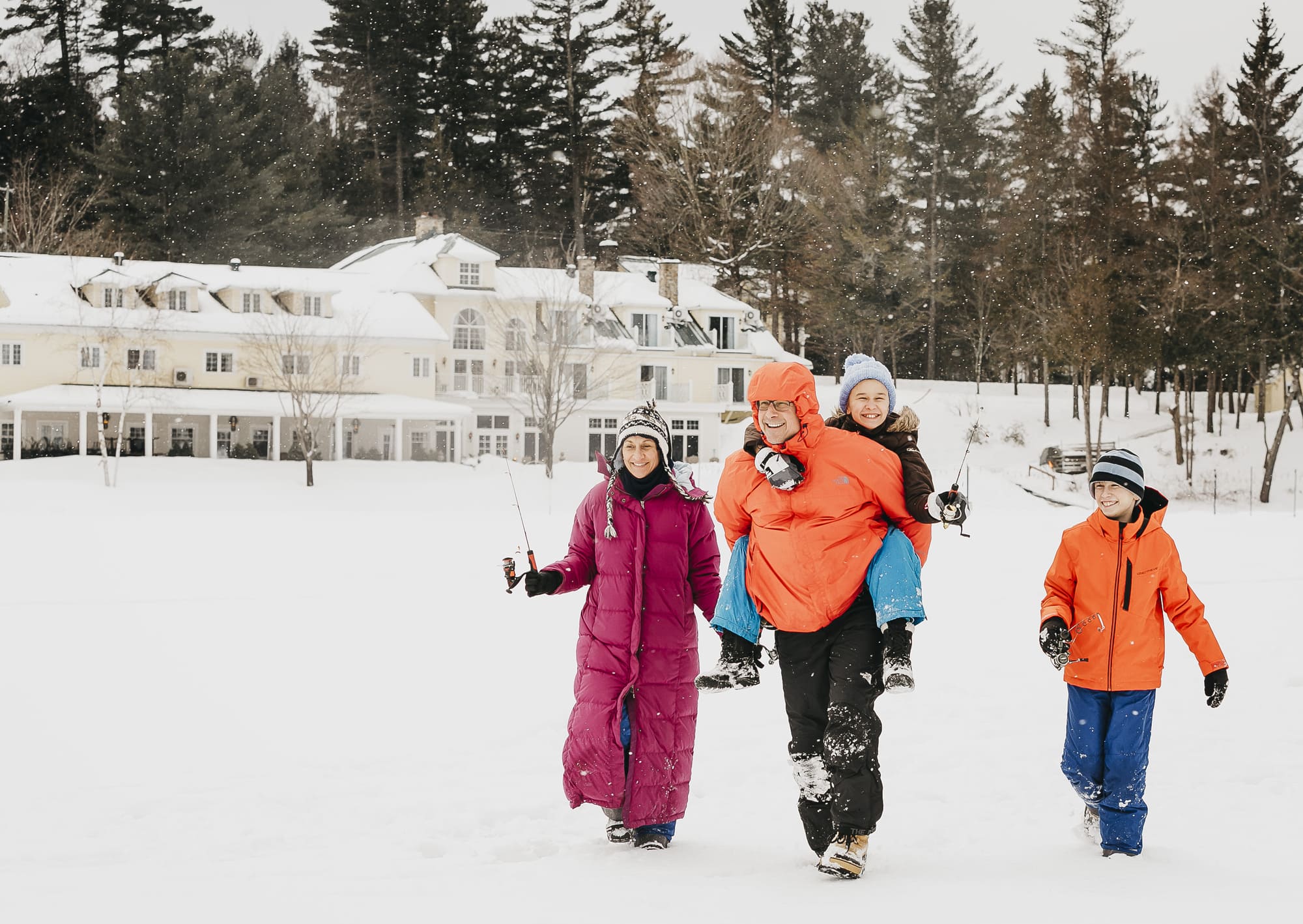 Famille équipée de canne à pêche, se dirigeant vers le lac Massawippi pour une activité hivernale en Estrie