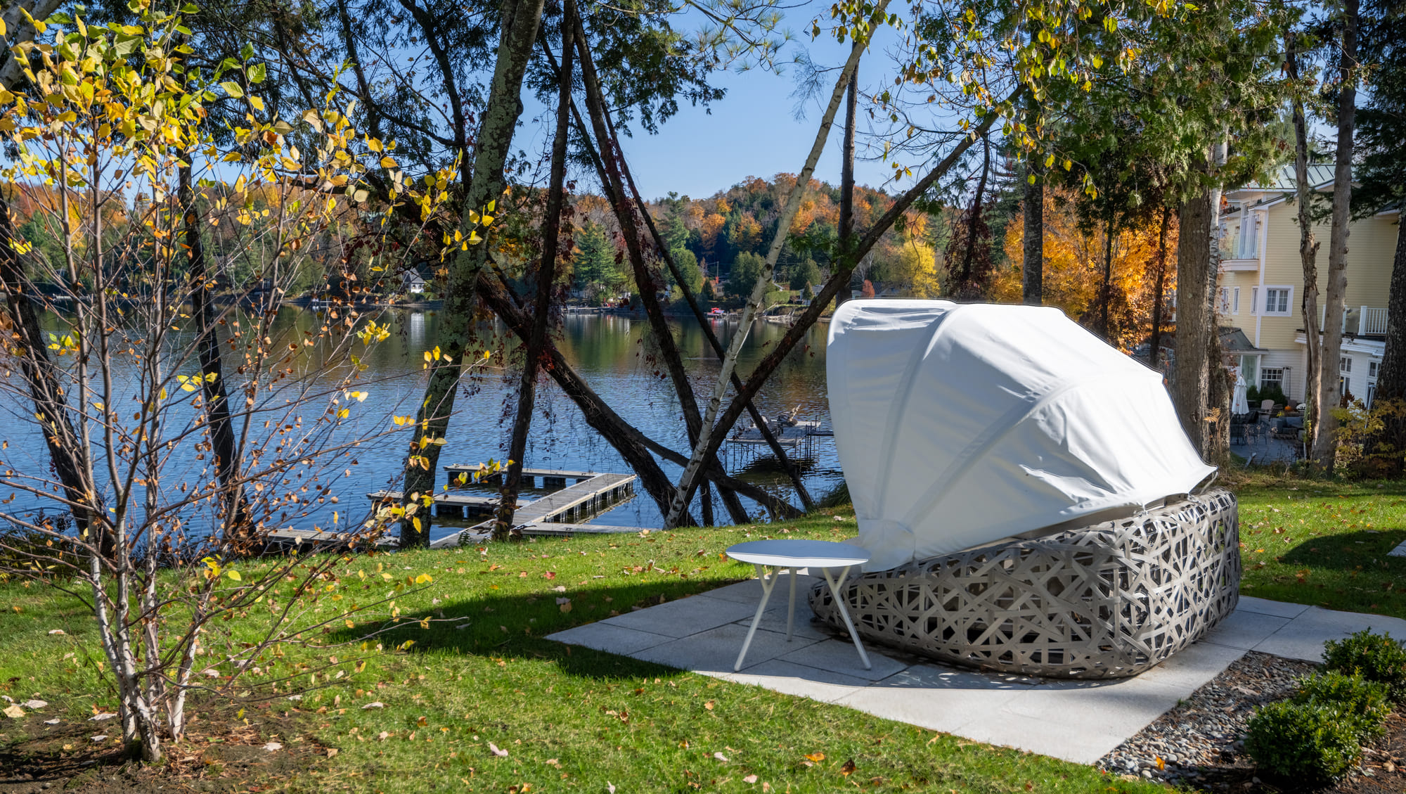 Espace de détente extérieur du Ripplecove avec vue sur le lac, bordé d'arbres.