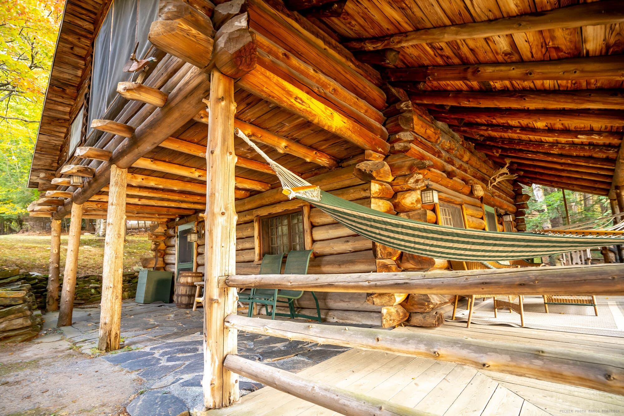 Chalet en bois rond du Ripplecove avec terrasse couverte et hamac.