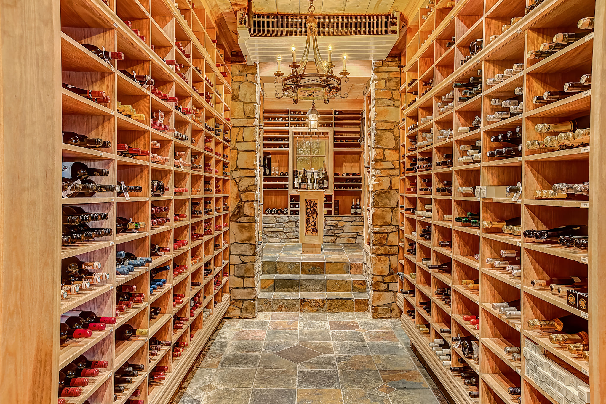 Perspective sur l'allée de la cave à vin du Ripplecove, avec rangées de bouteilles soigneusement conservées dans un décor chaleureux.