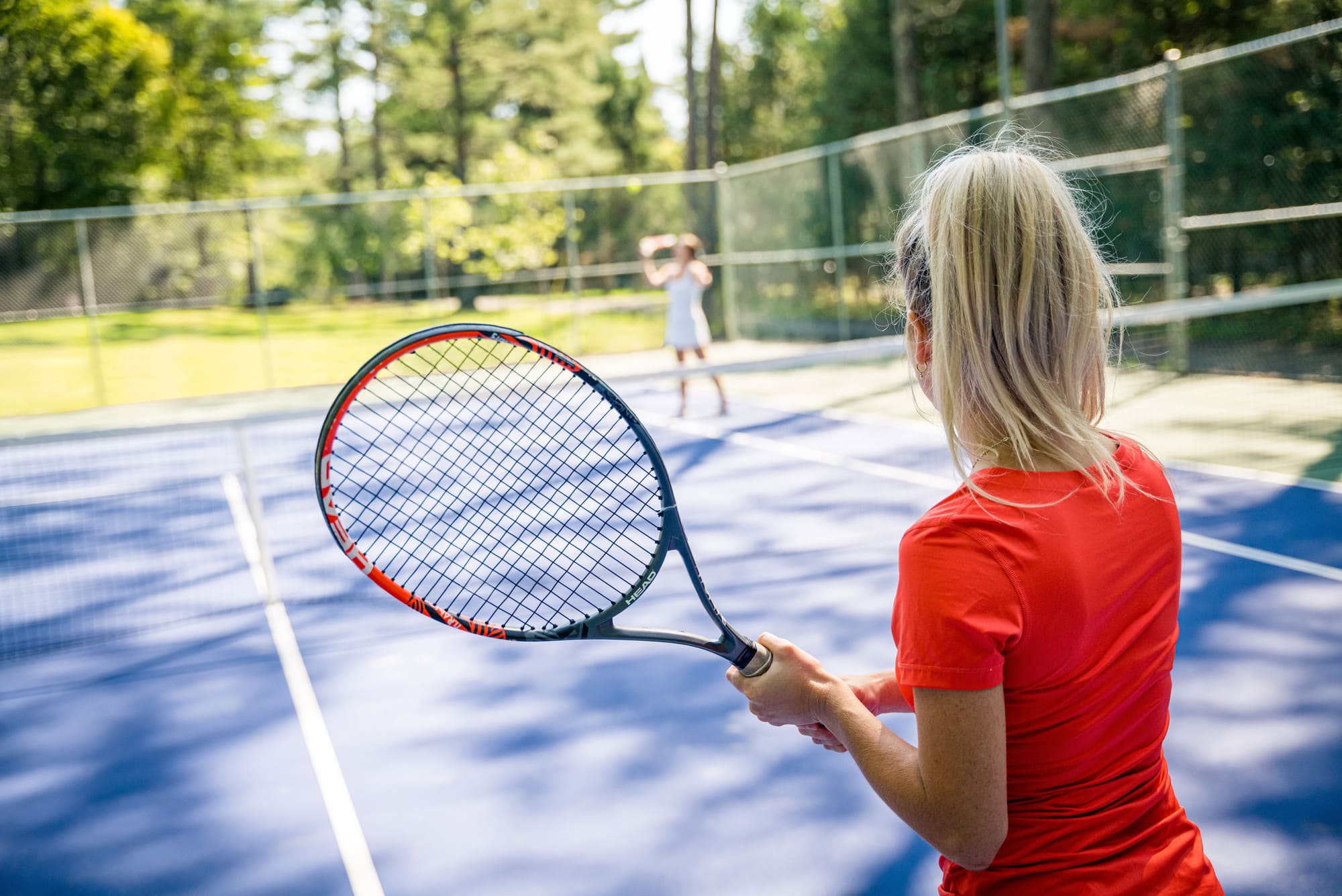 Partie de tennis sur un terrain extérieur en Estrie lors d’une retraite d’entreprise axée sur le team building.