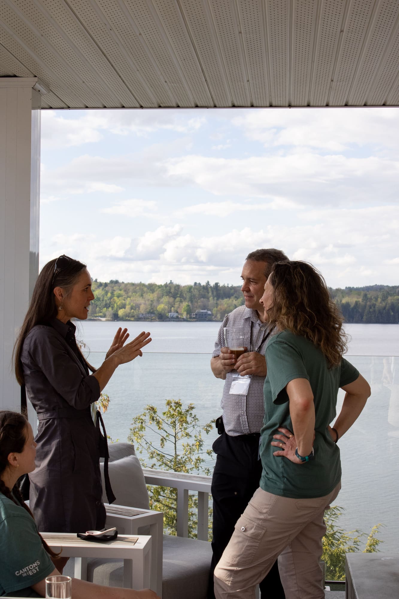 Participants à un séminaire corporatif sur une terrasse de l’Hôtel Ripplecove avec vue sur le lac Massawippi.